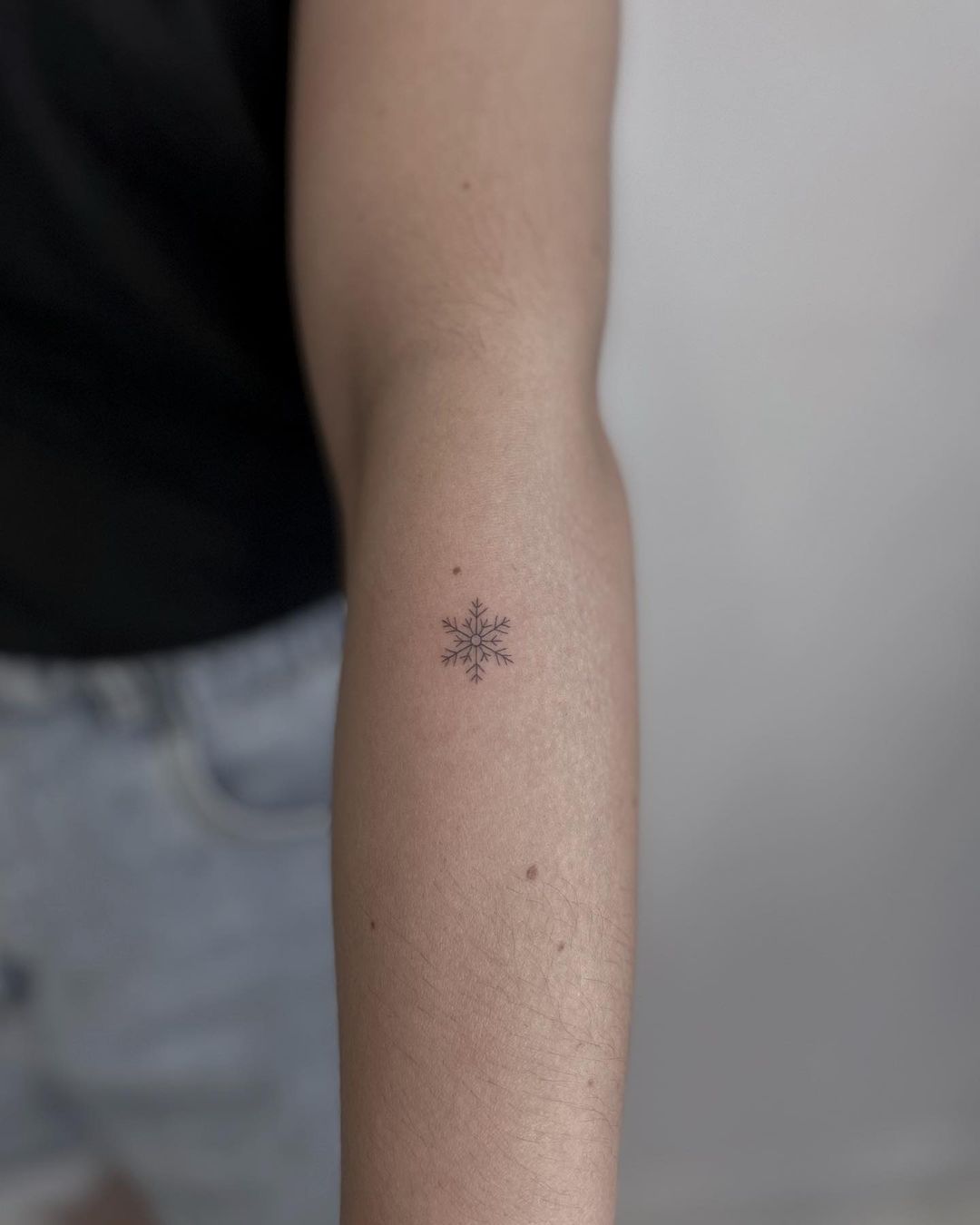 Small snowflake tattoo by roma.ink