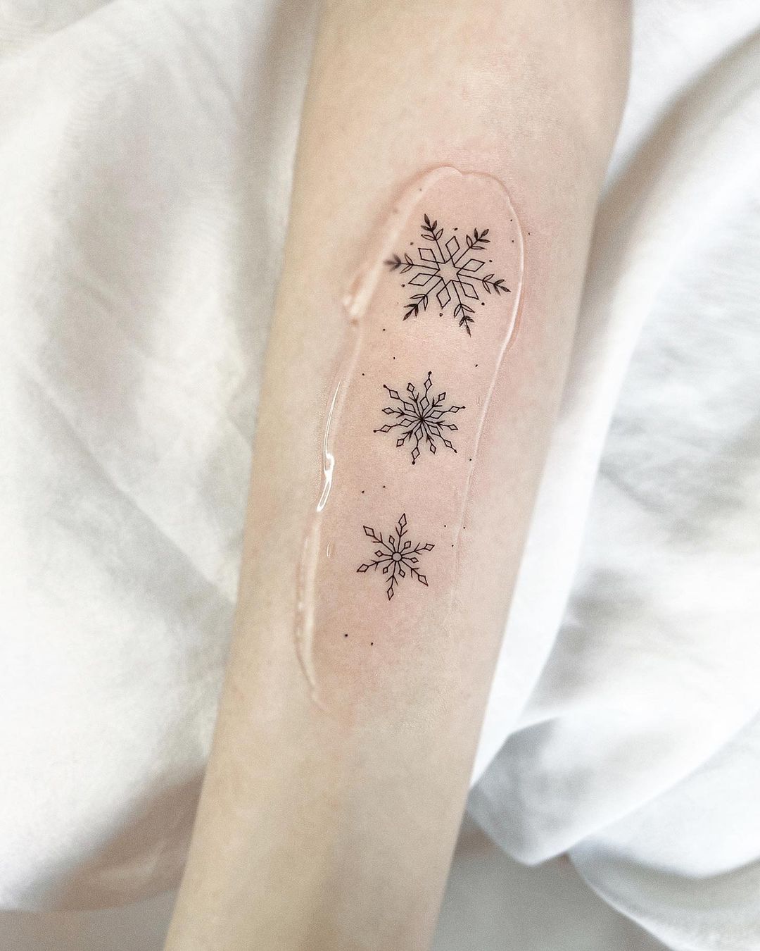 Snowflake tattoo on forearm by mariash.ink