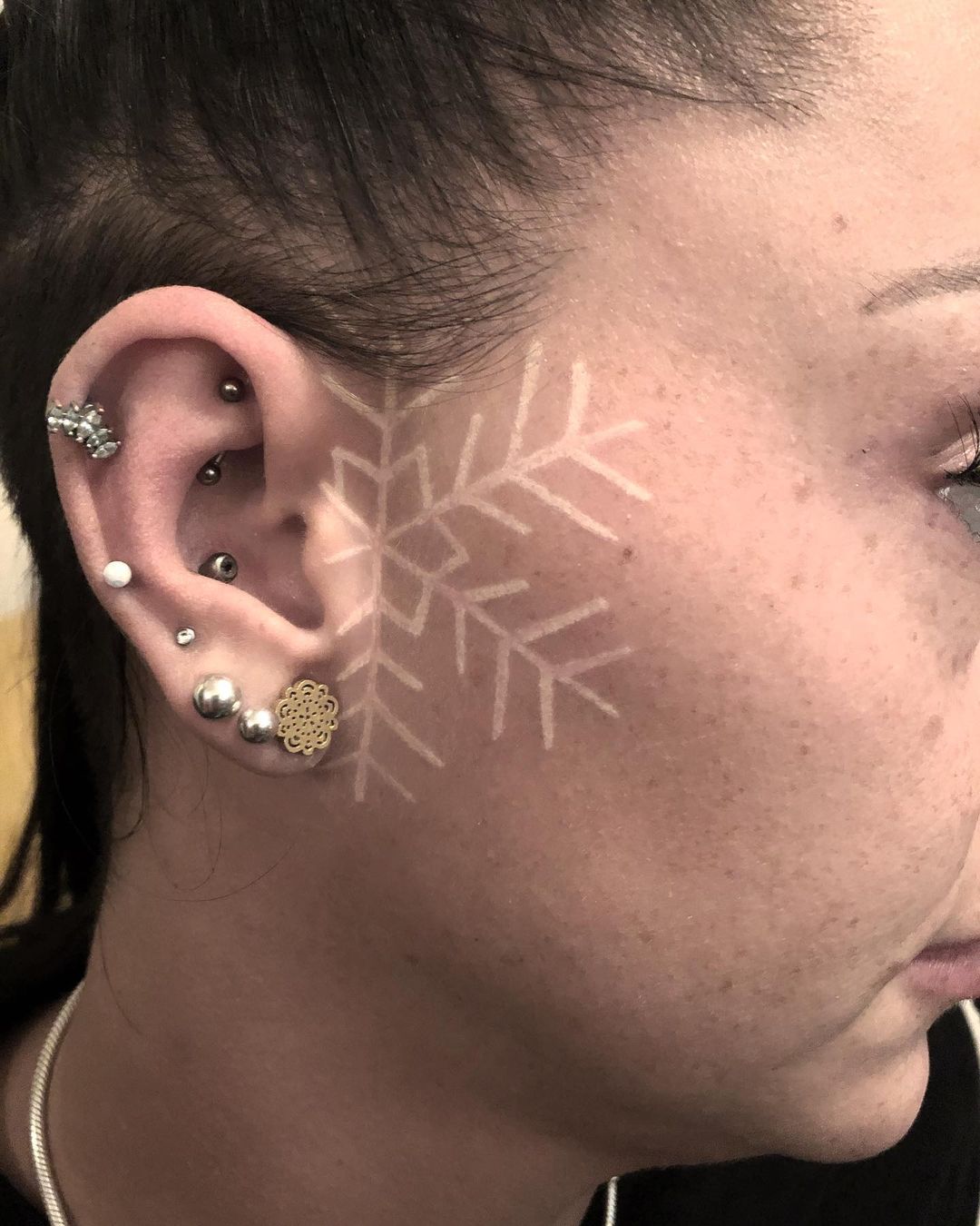snowflake tattoo on face by