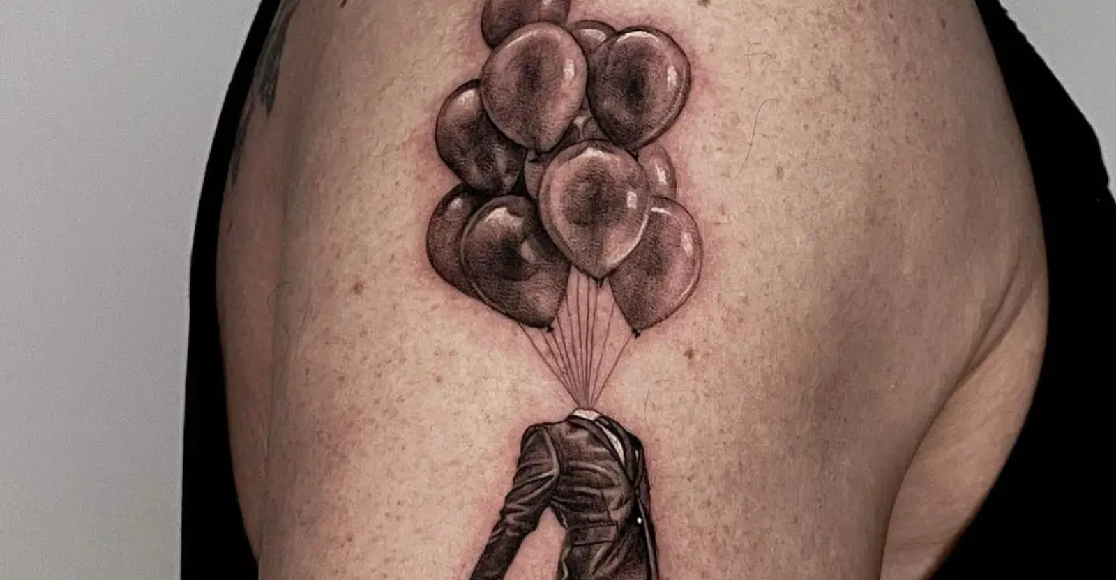 Surrealist air balloon tattoo on the right shoulder