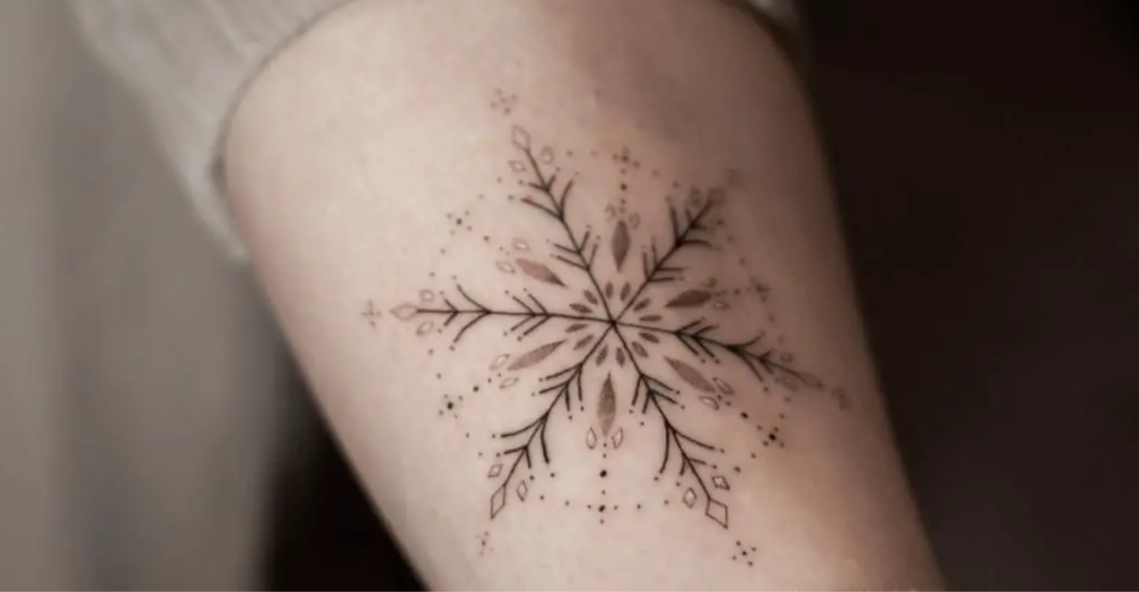 Snowflake tattoo on the right inner arm.