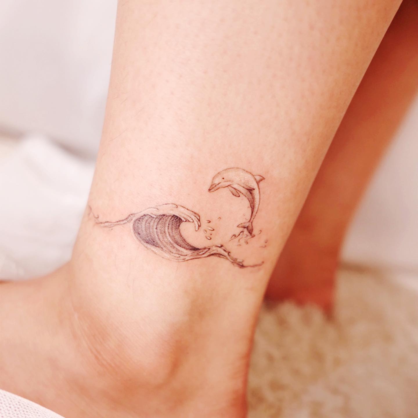 small dolphin design by tattooist cheeu