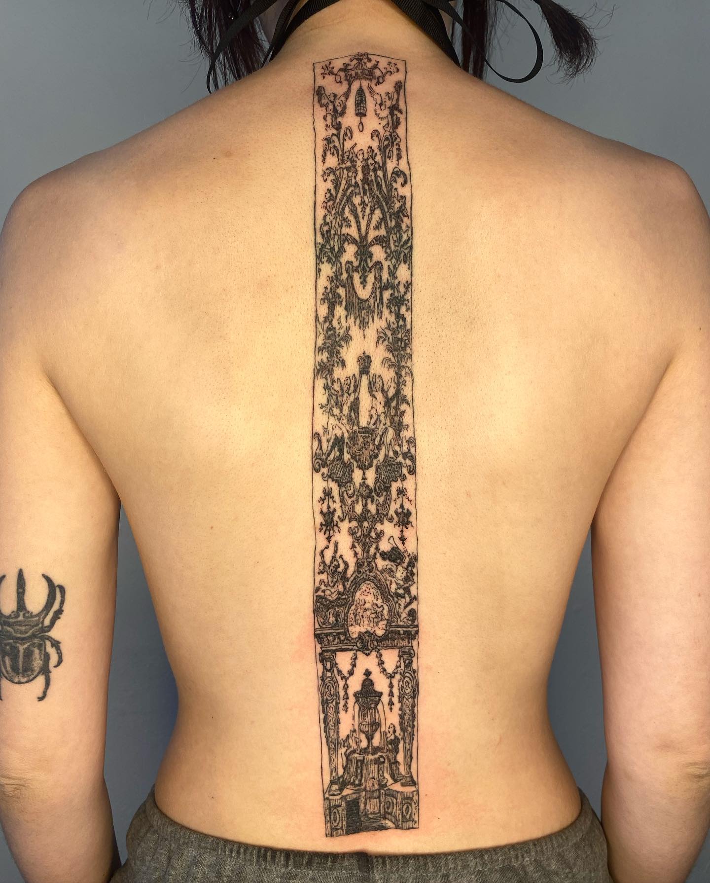 Black inked spine design by shell station tattoo