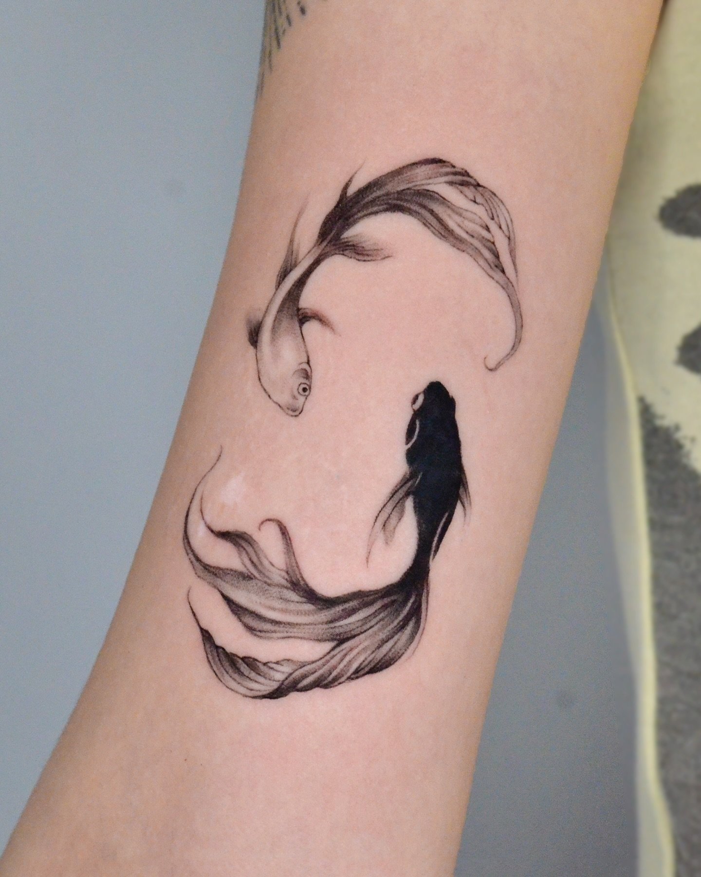 Black inked fish tattoos by dokbi tattoo